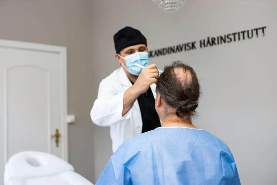 Hårlege tegner på pannen til pasient med en svart tusj.