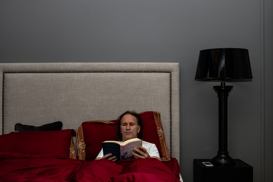 Mannlig pasient som slapper i klinikksuiten og leser bok. 