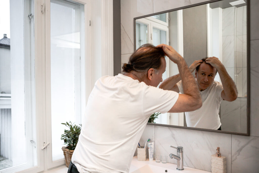 Mann som sjekker vikene i speilet. 